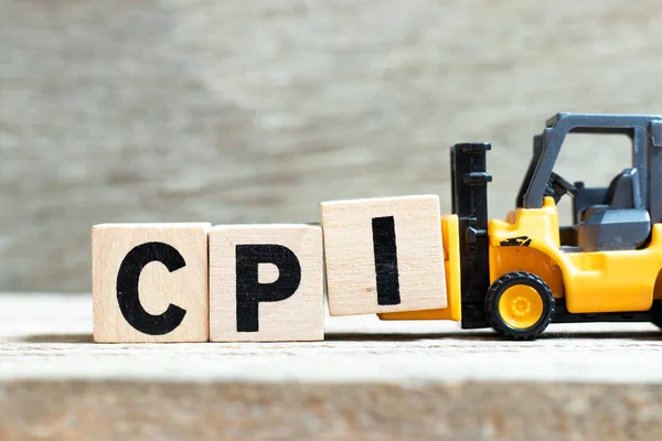 Toy forklift hold letter block I to complete word CPI (abbreviation of Consumer Price Index) on wood background — Stock Photo, Image