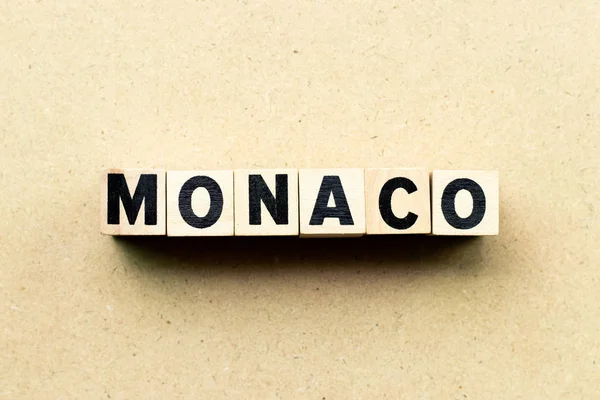 Blok literowy w słowie Monako na tle drewna — Zdjęcie stockowe
