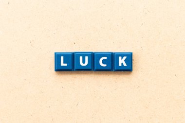 Tile letter in word luck on wood background