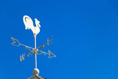 Beyaz horoz weather vane Haritayı mavi gökyüzü arka plan üzerinde rüzgar yönü