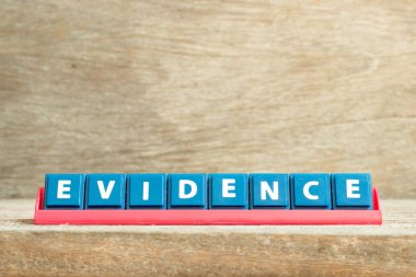 Tile letter on red rack in word evidencde on wood background