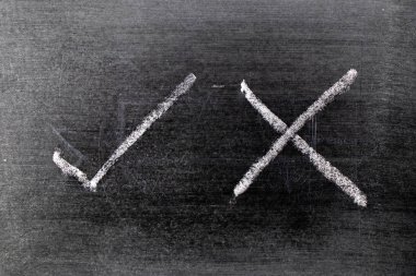 Beyaz renk tebeşir el kara tahta arka plan üzerinde onay işareti doğru ve yanlış şeklinin çizimi