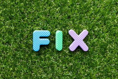 Yeşil çimen arka planında kelime düzeltmeli oyuncak köpük harfi