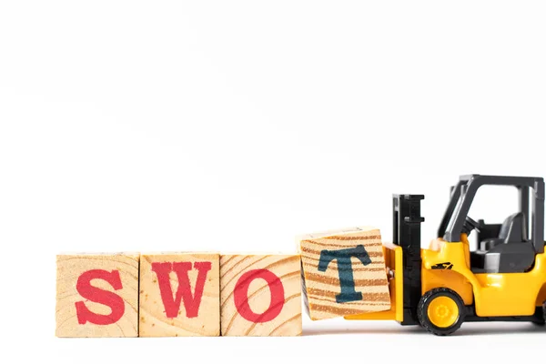 Speelgoedvorkheftruck houdt hout letter blok t om woord swot (afkorting van kracht, zwakte, kansen, bedreigingen) op witte achtergrond te voltooien — Stockfoto