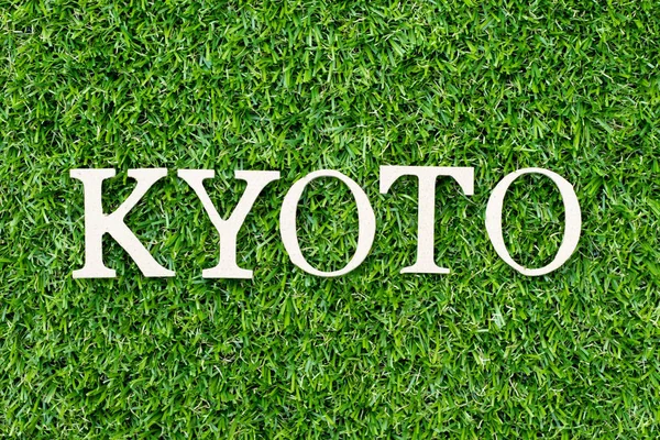 Alfabeto de madeira letra em palavra Kyoto no fundo grama verde — Fotografia de Stock