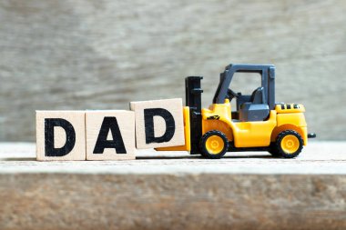 Toy forklift ahşap arka plan üzerinde kelime baba tamamlamak için mektup blok d tutun