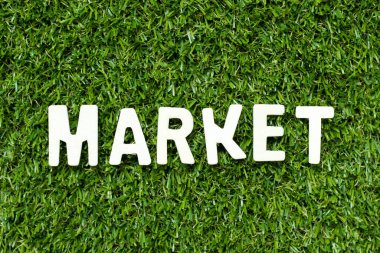 Alphabet letter in word market on artificial green grass background