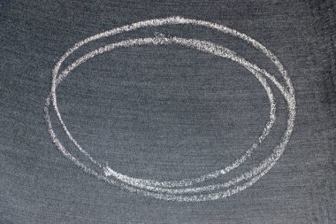 Beyaz renkli tebeşirle çizilen el veya siyah tahta arka planda oval şekil