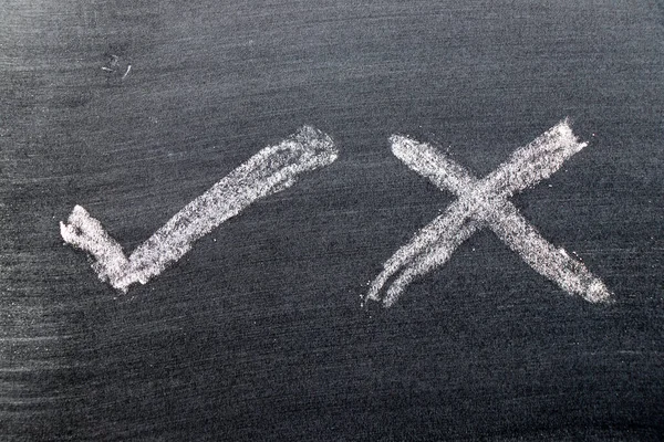 Siyah tahta arka planında doğru ve yanlış şekil işaretli beyaz tebeşirli el çizimi