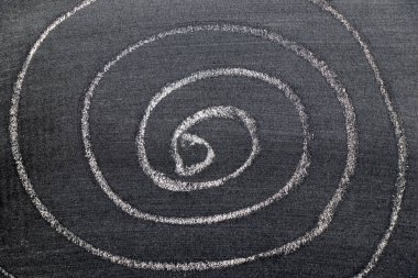 Siyah tahta zemin üzerinde sarmal şekilli beyaz tebeşirli el çizimi
