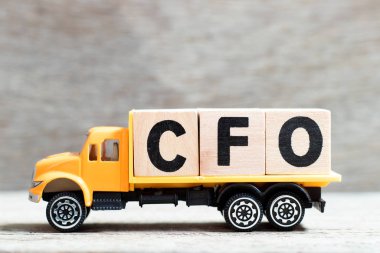 Truck hold letter block in word CFO (Abbreviation of Chief Financial Officer) on wood background