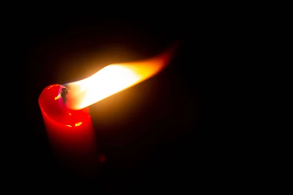 Red candle with yellow flame on black background — Stock Photo, Image