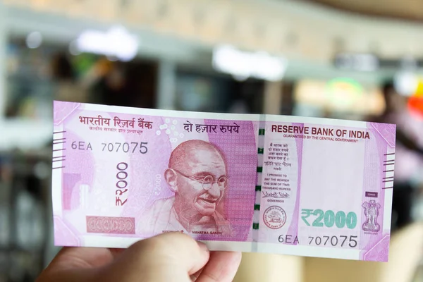 Mężczyzna trzymać 2000 rupii banknot z zamazanym tle — Zdjęcie stockowe