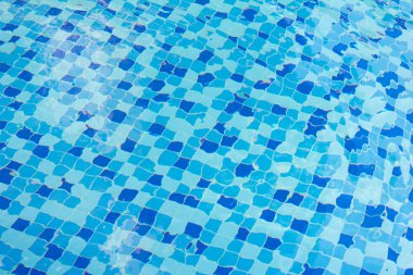 Mavi döşemeli yüzme havuzunda dalgalı su