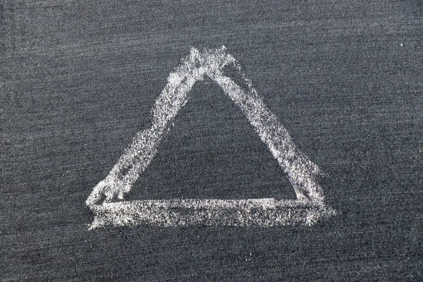 White color chalk hand drawing in triangle shape on black board background