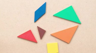 Tangram puzzle ahşap arka planda kalp şeklinde birleşir (Aşk kavramı)