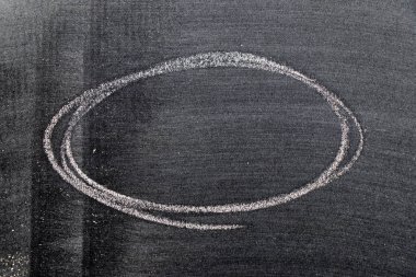 Beyaz renkli tebeşirle çizilen el veya siyah tahta arka planda oval şekil