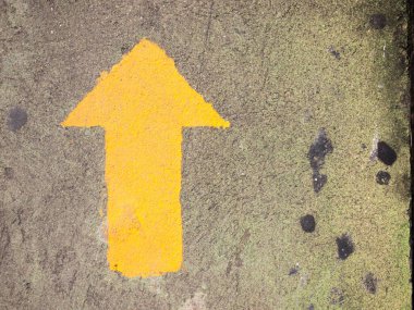 Gri beton arkaplanda sarı ok resmi