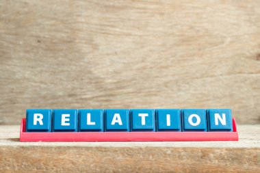 Ahşap arkaplanda kelime ilişkili kırmızı raftaki döşeme harfi