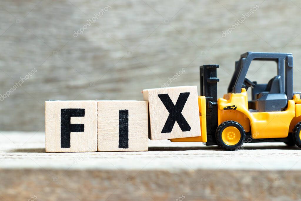 Toy forklift hold letter block x to complete word fix on wood background