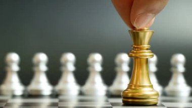 Altın kral satranç taşı siyah arka planda gümüş piyon takımını yendi ve kazandı (Şirket stratejisi, iş zaferi veya karar kavramı)