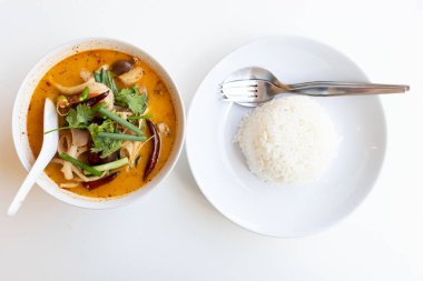 Tom Yum mantarı kasede ve pirinç tabağı beyaz masa arkasında