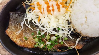 Dilimlenmiş saba uskumrusu, salata ve pirinç arkaplanlı.