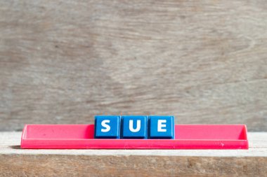 Kırmızı raftaki döşeme harfi. Ahşap arka planda dava aç.