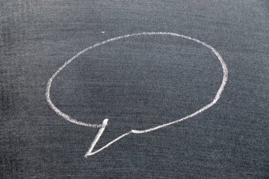 Siyah tahta arka planında boş alanı olan yuvarlak baloncuk konuşma şeklinde beyaz tebeşirli el çizimi