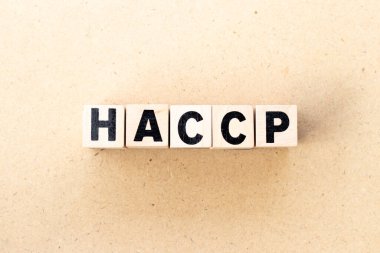 Letter block in word HACCP (Hazard Analysis Critical Control Points) on wood background