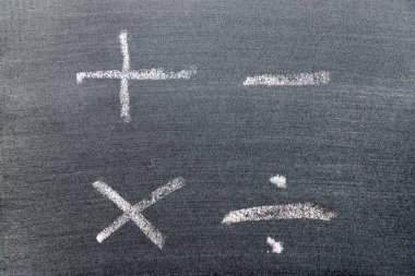 Matematik sembolü şeklinde beyaz renkli tebeşir el çizimi (Artı, eksi, çarpma, bölme) kara tahta arka planında