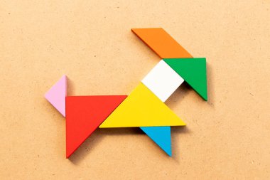 Ahşap arka planda keçi şeklinde renkli tangram yapbozu