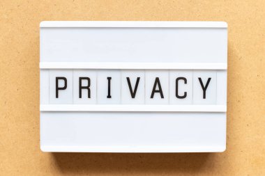 Ahşap arka planda kelime gizliliği olan ışık kutusu