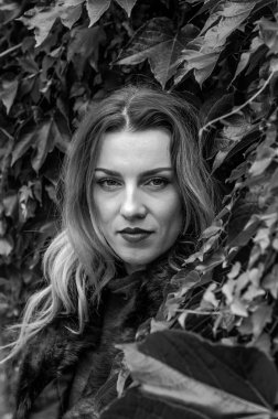 Dekoratif duvar yakın duran uzun saçlı Genç Sevimli Kadın vahşi üzüm sonbahar günü bırakır