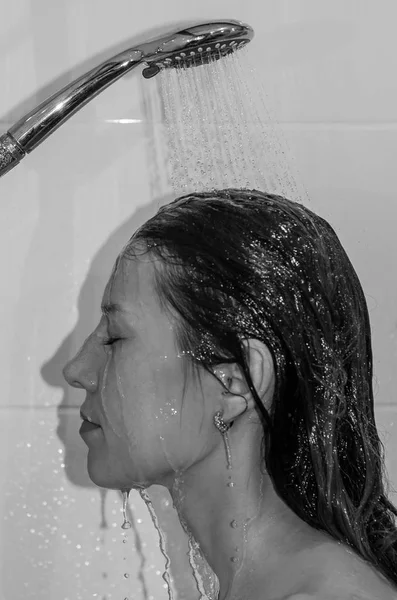 Jeune belle fille aux cheveux longs, nue, prenant une douche et se lavant la tête — Photo