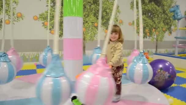 Criança menina brincando no carrossel em um parque de diversões — Vídeo de Stock