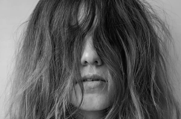 Egy fiatal lány arca borított hosszú haj — Stock Fotó
