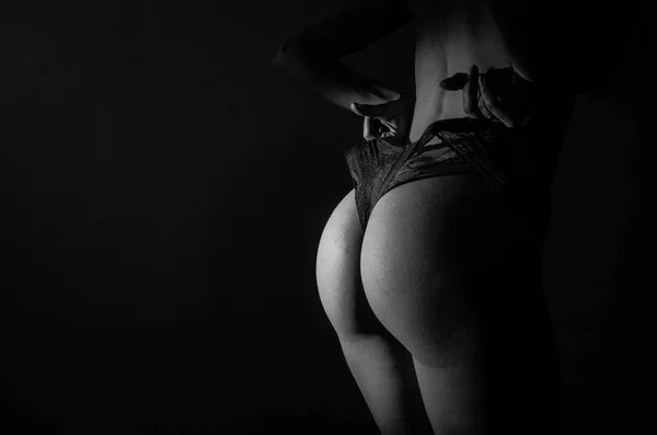 Обнажённое женское тело в кружевных сексуальных трусиках на тёмном фоне — стоковое фото