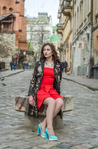 Menina bonita nova em um vestido vermelho passeia pelas ruas antigas da cidade de Lviv — Fotografia de Stock