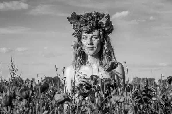 Портрет молодой красивой девушки на маковом поле с маковым венком на голове в жаркий солнечный летний день — стоковое фото