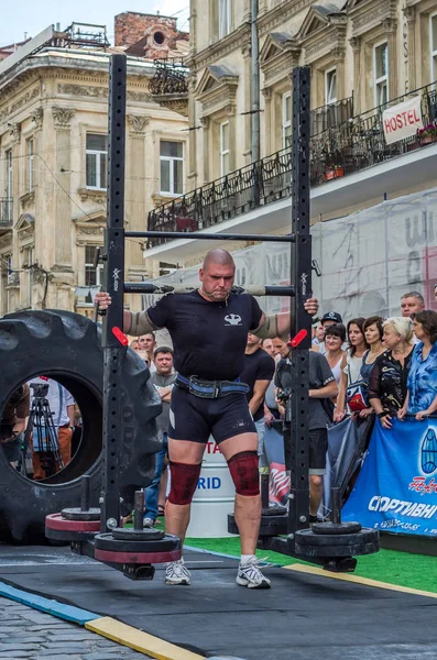 LVIV, UCRANIA - AGOSTO 2017: Fuerte atleta lleva un gran rockero pesado en los juegos heroicos en el juego Strongmen — Foto de Stock