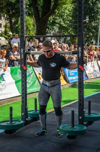 LVIV, UCRANIA - AGOSTO 2017: Fuerte atleta lleva un gran rockero pesado en los juegos heroicos en el juego Strongmen — Foto de Stock