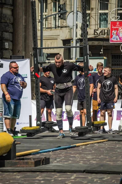 LVIV, UCRANIA - AGOSTO 2017: Fuerte atleta lleva un gran rockero pesado en los juegos heroicos en el juego Strongmen — Foto de Stock