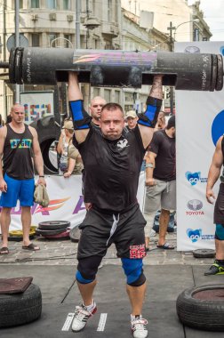 Lviv, Ukrayna - Ağustos 2017: Güçlü bir atlet hayran Strongmen Oyunları'nda seyirci önünde başını halter bir büyük ağır toparlayabiliriz alır