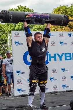 Lviv, Ukrayna - Ağustos 2017: Güçlü bir atlet hayran Strongmen Oyunları'nda seyirci önünde başını halter bir büyük ağır toparlayabiliriz alır