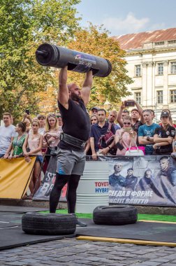 Lviv, Ukrayna - Ağustos 2017: Güçlü bir atlet hayran Strongmen Oyunları'nda seyirci önünde başını halter bir büyük ağır toparlayabiliriz alır