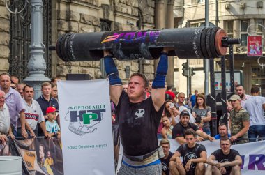 Lviv, Ukrayna - Ağustos 2017: Güçlü bir atlet hayran Strongmen Oyunları'nda seyirci önünde başını halter bir büyük ağır toparlayabiliriz alır