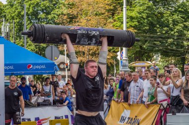 Lviv, Ukrayna - Ağustos 2017: Güçlü bir atlet hayran Strongmen Oyunları'nda seyirci önünde başını halter bir büyük ağır toparlayabiliriz alır