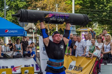 Lviv, Ukrayna - Ağustos 2017: Güçlü bir atlet hayran Strongmen Oyunları'nda seyirci önünde başını halter bir büyük ağır toparlayabiliriz alır