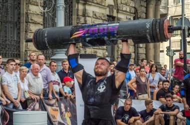 Lviv, Ukrayna - Ağustos 2017: Güçlü bir atlet hayran Strongmen Oyunları'nda seyirci önünde başını halter bir büyük ağır toparlayabiliriz alır